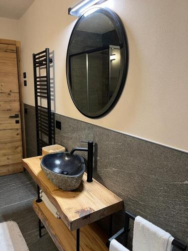 a bathroom with a sink and a mirror at Remina Dolomiti house in Tonadico