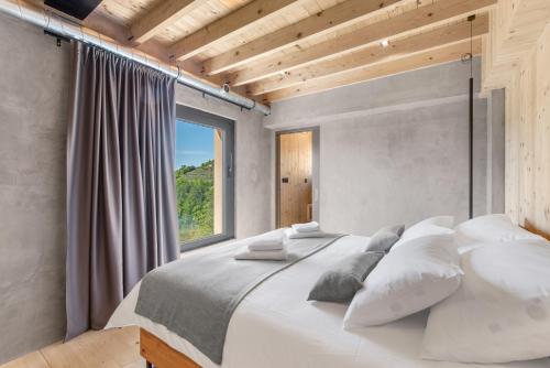1 dormitorio con 1 cama blanca grande y ventana en Villa Terra Motovun, en Motovun