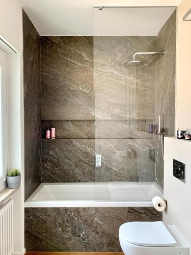 a bathroom with a tub and a toilet at Live Lugano - Via Madonetta in Lugano