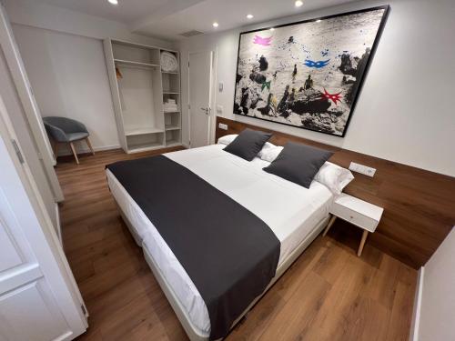 ein Schlafzimmer mit einem großen Bett und einem Gemälde an der Wand in der Unterkunft Old Town Flats Casa del Bisbe in Valencia