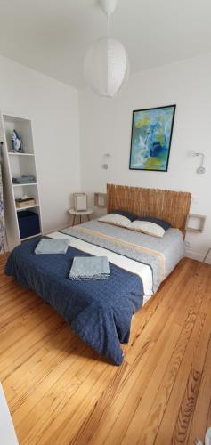 une chambre avec un lit et un parquet dans l'établissement Apparts centre ville Lorient-calme&cosy, à Lorient