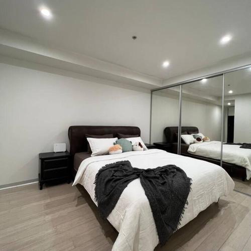 1 dormitorio con 1 cama grande y espejo grande en Carlton Stunning View Apartment 150m away from University of Melbourne, en Melbourne