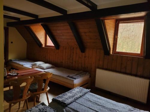 una habitación con 2 camas y una mesa en una habitación en Zachęta, en Sokolec