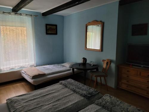 a room with two beds and a table and a mirror at Zachęta in Sokolec