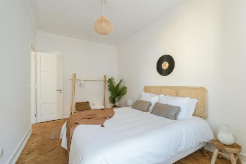 um quarto branco com uma grande cama branca com almofadas em Casa Boma Lisboa - Charming and Spacious Apartment - Campolide II em Lisboa