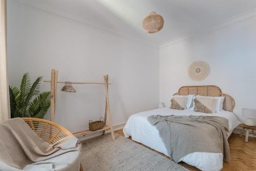 a white bedroom with a bed and a chair at Casa Boma Lisboa - Charming and Spacious Apartment - Campolide II in Lisbon