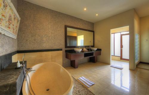 a bathroom with a large tub and a sink at Bali Rich Villas in Seminyak