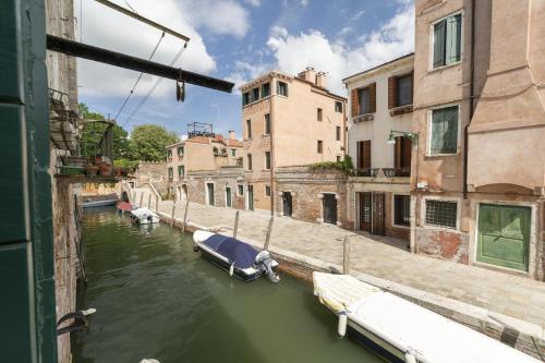 a group of boats in a canal with buildings at CA FOSCA HOME - Campo Santa Fosca in Venice