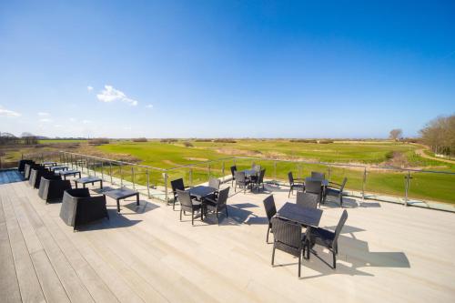 a group of tables and chairs on a deck at Heacham Manor Hotel in Hunstanton