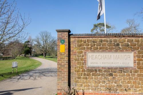 a brick wall with a sign in a park at Heacham Manor Hotel in Hunstanton