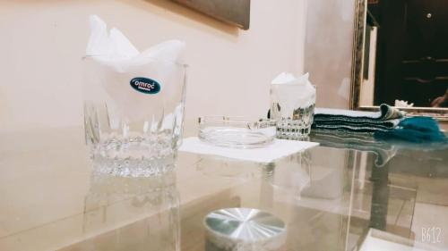 uma mesa de vidro com um lavatório e um espelho em The Elet Business Hotel em Carachi