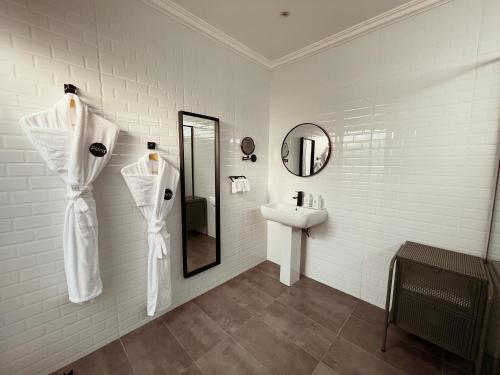 a white bathroom with a sink and a mirror at Pura Eco Retreat, Jubail Island in Abu Dhabi