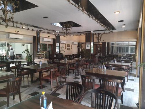 um restaurante com mesas e cadeiras de madeira numa sala em Woodlands em Bangalore