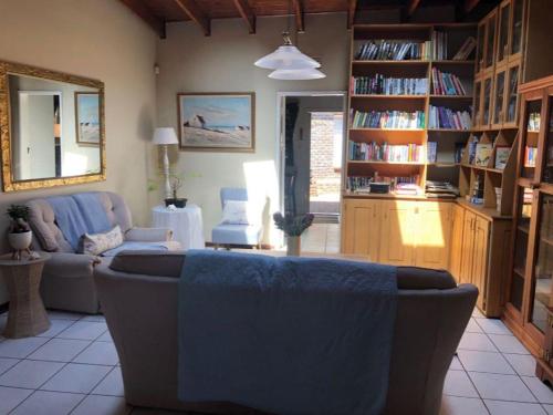 sala de estar con sofá y estante para libros en Eliora, en Randfontein