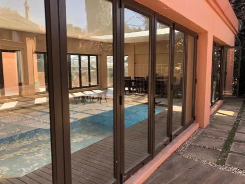 uma casa com portas de vidro e uma piscina em Eliora em Randfontein