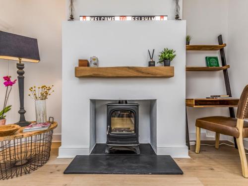 a living room with a fireplace with a black rug at Pass the Keys Delightful 2 Bed House a Stones Throw From Beach in Bognor Regis