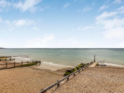 a beach with a fence and the ocean at Pass the Keys Delightful 2 Bed House a Stones Throw From Beach in Bognor Regis
