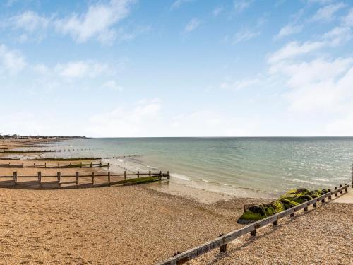 a beach with a fence and the ocean at Pass the Keys Delightful 2 Bed House a Stones Throw From Beach in Bognor Regis