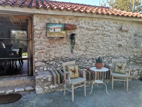 a stone house with two chairs and a table at Sofias cottage in Elliniko