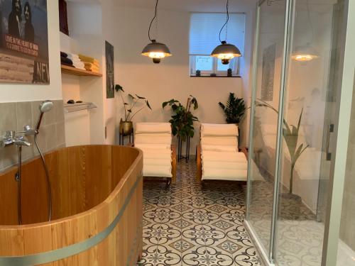 ein Badezimmer mit einer Holzbadewanne und einer Dusche in der Unterkunft Ferienhaus Mosel 2.0 in Bremm