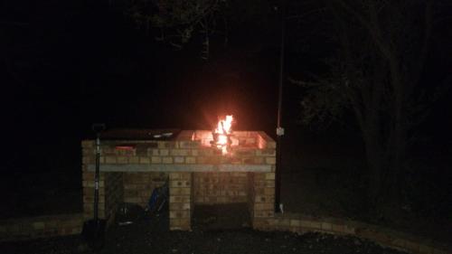 a brick fireplace at night with fire in it at Bushveld Magic in Klipdrift