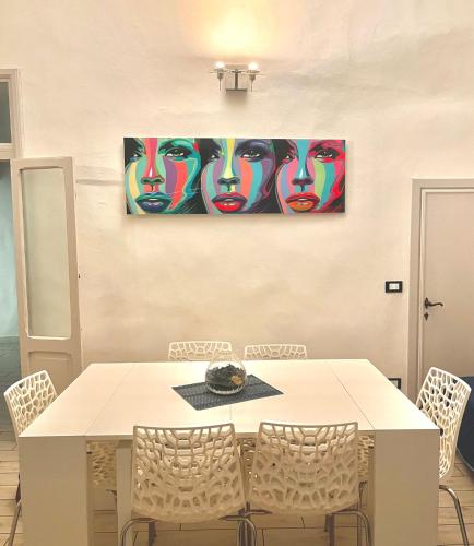 a dining room table with chairs and a painting on the wall at Appartamento Merilu in Civita Castellana