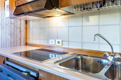 a kitchen with a stainless steel sink and a stove at Pension Sonia App 103 in Funes