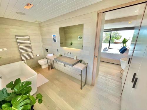 un bagno con vasca, lavandino e letto di The Beach Hytte - Stunning Sea View Penthouse a Bournemouth