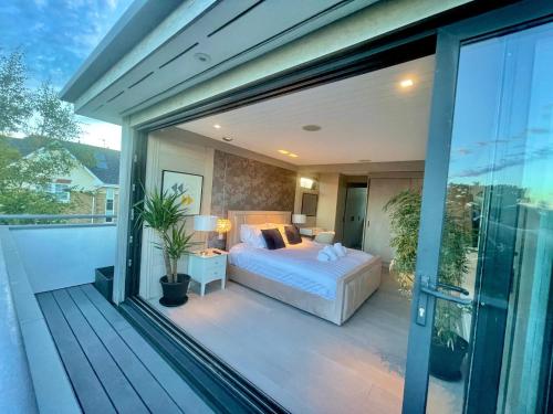 ボーンマスにあるThe Beach Hytte - Stunning Sea View Penthouseのベッドルーム1室(ベッド1台付)、バルコニー