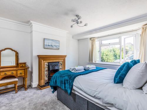 a bedroom with a bed with blue pillows and a fireplace at Pass The Keys Lovely Ground Floor Flat With Large Garden in Chichester