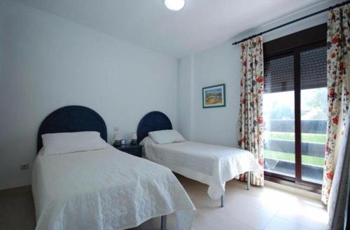 マルベーリャにあるLa Maestranzaのベッドルーム1室(ベッド2台、窓付)