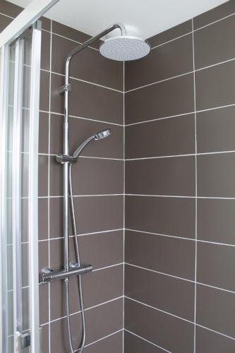 une douche avec pommeau de douche dans une salle de bain dans l'établissement Gîte Le Coq Au Vert en Suisse Normande, à Hamars