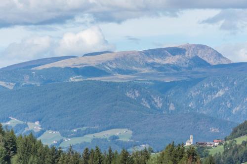 a view of a mountain range with a town and a lake at Pension Sonia App 103 in Funes