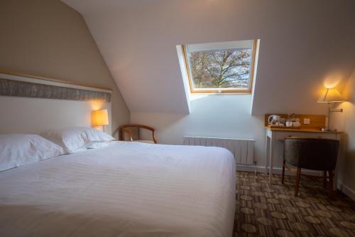 a bedroom with a white bed and a window at Heacham Manor Hotel in Hunstanton