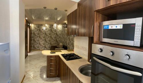 a small kitchen with a sink and a microwave at Ogienka 2b, Center Lutsk in Lutsk