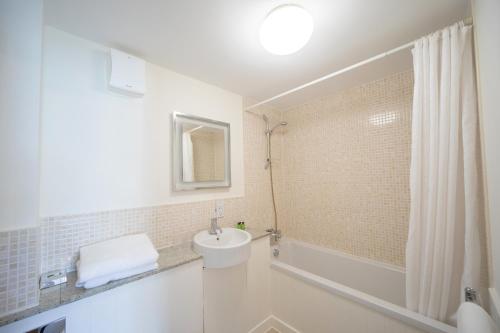 a bathroom with a sink and a toilet and a shower at Heacham Manor Hotel in Hunstanton