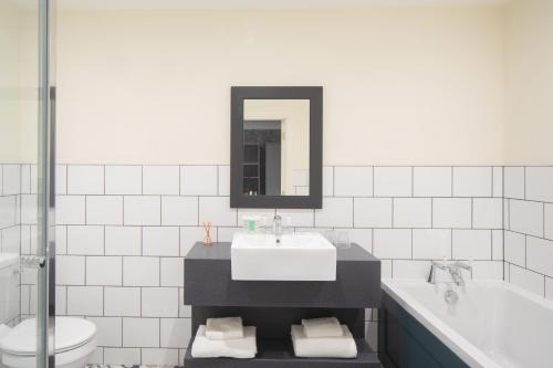 a bathroom with a sink and a tub and a toilet at Heacham Manor Hotel in Hunstanton