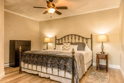 1 dormitorio con 1 cama y ventilador de techo en Strictly Moose Luxury Vacation Suites, en Gorham