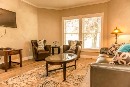 a living room with a couch and chairs and a table at Strictly Moose Luxury Vacation Suites in Gorham
