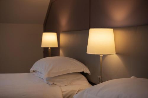 a bedroom with a bed with two lamps on it at Heacham Manor Hotel in Hunstanton