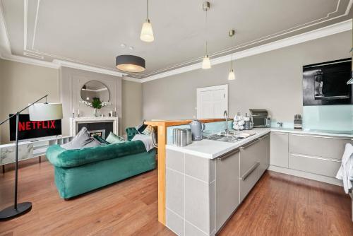 a kitchen and a living room with a green couch at Stunning Georgian Apartment In Yorkshire - Parking in Wakefield