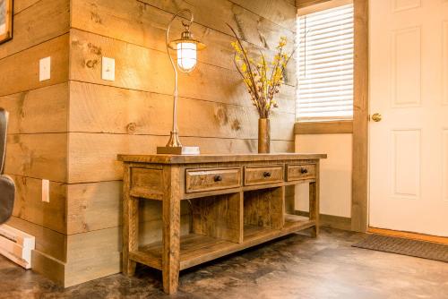 una mesa de madera con un jarrón en una habitación en Strictly Moose Luxury Vacation Suites, en Gorham