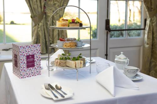 a table with three tiered cakes and desserts on a plate at Heacham Manor Hotel in Hunstanton