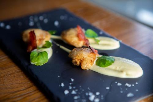 a black plate with food on a wooden table at Heacham Manor Hotel in Hunstanton