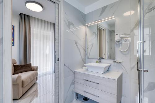 La salle de bains est pourvue d'un lavabo et d'un miroir. dans l'établissement Vomero High Hotel, à Naples