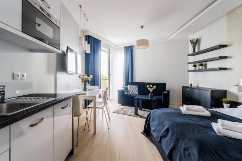 eine Küche und ein Wohnzimmer mit einem Bett in einem Zimmer in der Unterkunft Flatbook Apartamenty - Kąty Rybackie Marina in Kąty Rybackie