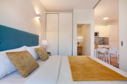 a bedroom with a large white bed with a blue headboard at D&S - Porto São Bento Apartments III in Porto
