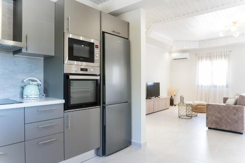 a kitchen with a stainless steel refrigerator with a microwave at Villa Vrahinari in Kounopetra