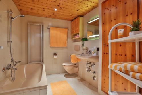 y baño con bañera, aseo y lavamanos. en Haus Langbruck Ferienwohnungen, en Ramsau