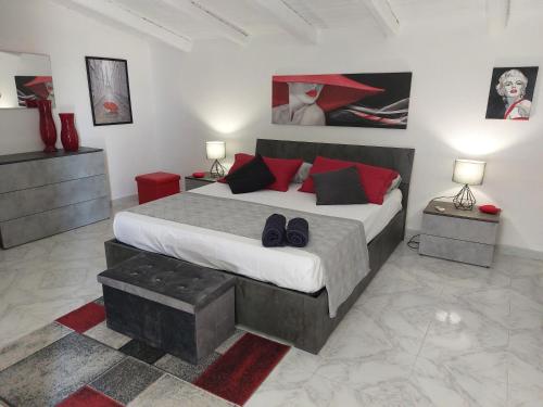 a bedroom with a large bed with red pillows at Mamà Apartment in Augusta